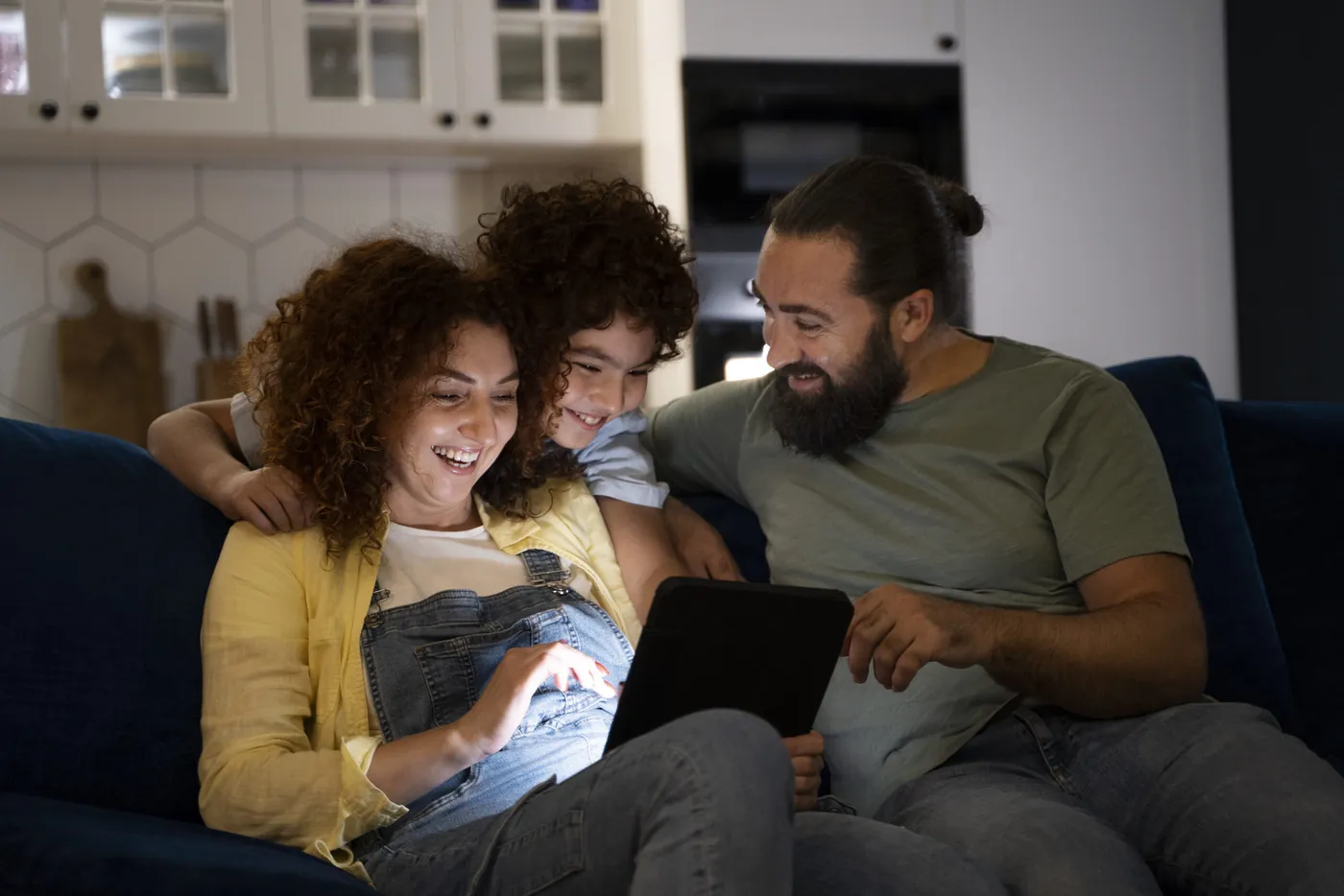 Família reunida usando um tablet no sofá